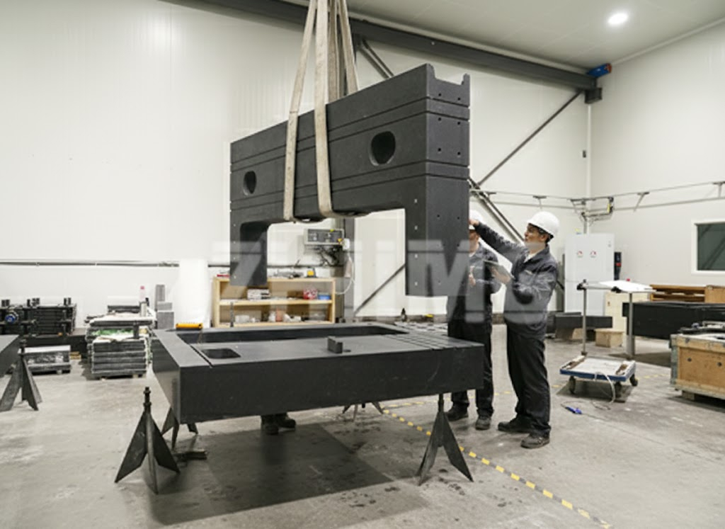ZHHIMG technicians assembling a granite beam onto a granite machine base in a temperature-controlled workshop