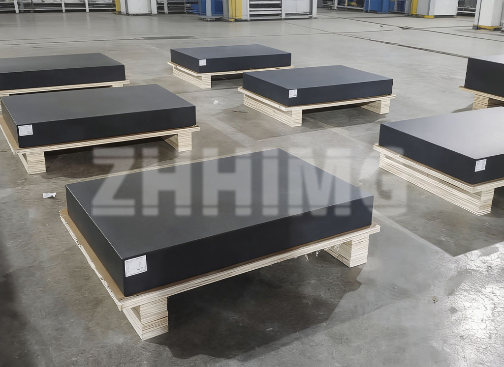 Black granite plates resting on support stands in the ZHHIMG factory storage area